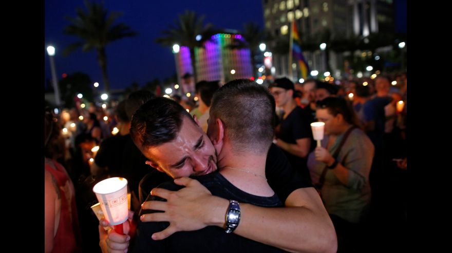 People embrace during a candlelight vigil at a memorial service for the victims of the shooting at the Pulse gay nightclub in Orlando, Florida, June 13, 2016. REUTERS/Jim Young
